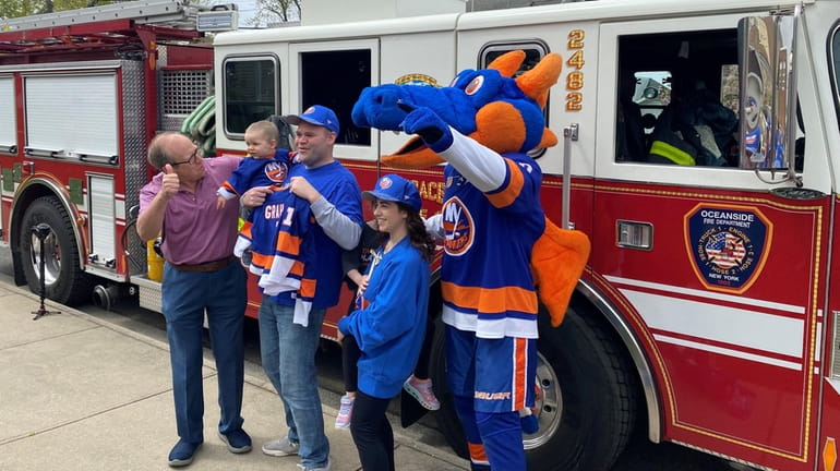 Islanders co-owner Jon Ledecky (far left) and team mascot "Sparky"...