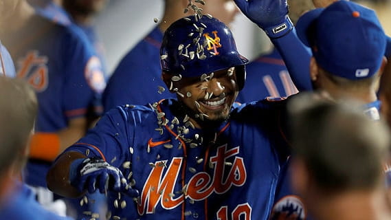 Eduardo Escobar of thhe Mets celebrates in the dugout after his...