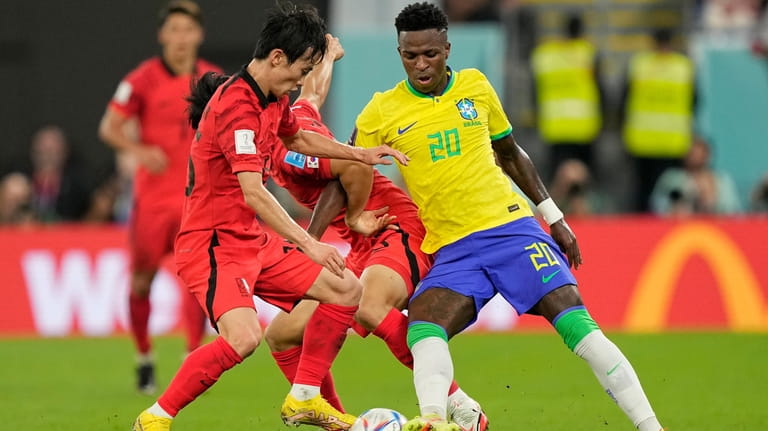 Brazil's Vinicius Junior, right, fights for the ball with South...