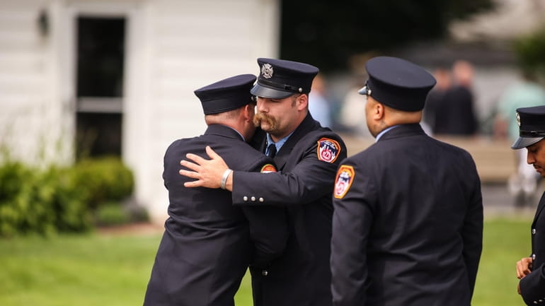 Firefighters embrace during the wake for Casey Skudin at Towers...