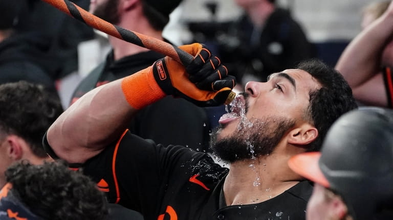Baltimore Orioles' Anthony Santander (25) drinks from a hose to...