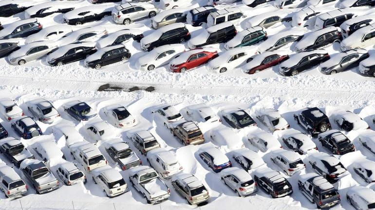 Superstorm Sandy damaged cars get a coating of snow from...