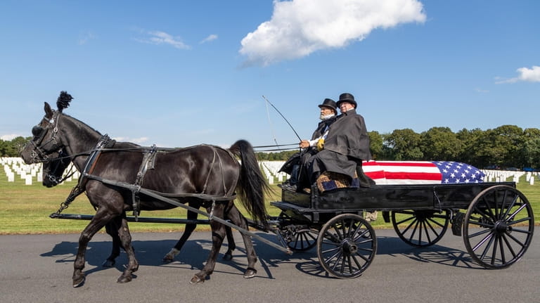 A horse-drawn caisson carries the remains of U.S. Army Sgt. Bernard...
