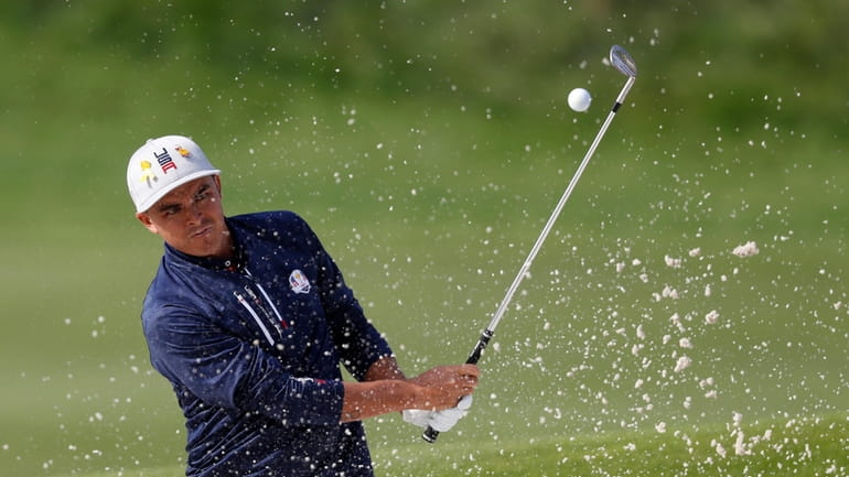Rickie Fowler, of the U.S., plays out of a bunker...