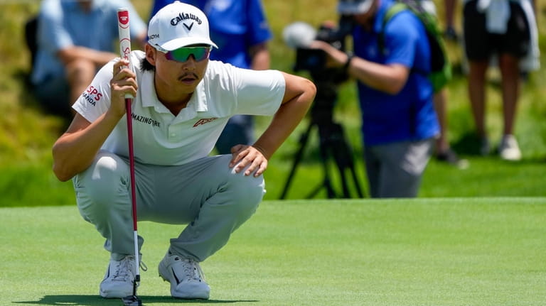 Australia's Min Woo Lee lines up his putt on the...