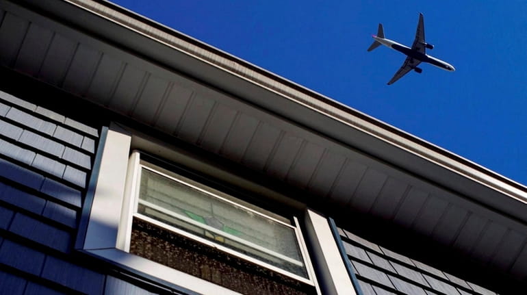 An airliner passes over a house in Floral Park on May 1,...