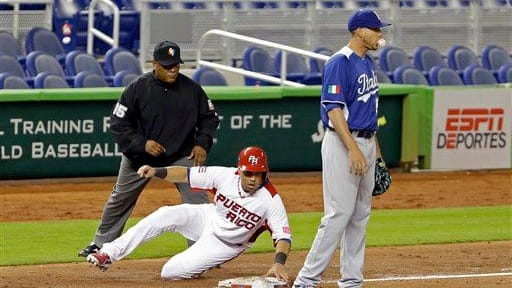 Puerto Rico's Carlos Beltran slides safely into third base on...