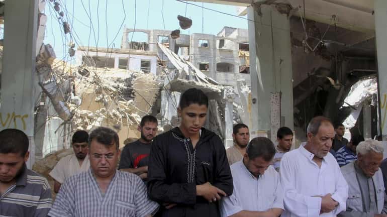 Palestinians pray the Friday prayer inside a destroyed Al Farouk...