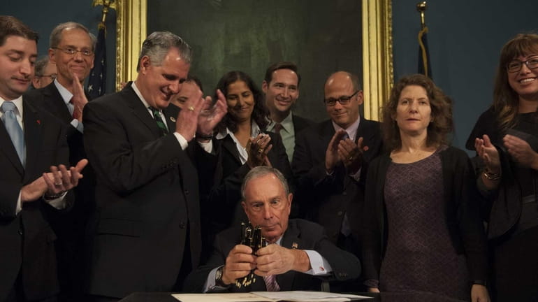 New York City Mayor Michael Bloomberg, seated, is joined by...
