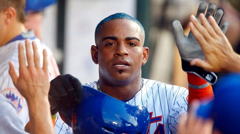 Yoenis Cespedes of the Mets celebrates in the dugout against...