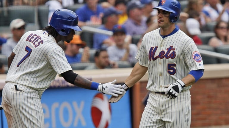 The Mets' David Wright is greeted by teammate Jose Reyes...