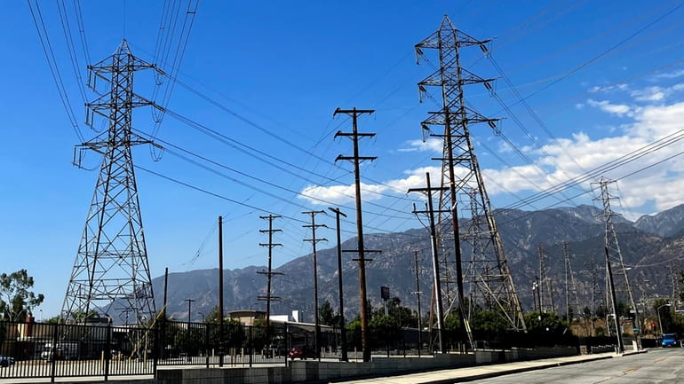 Electrical grid towers are seen during a heat wave where...