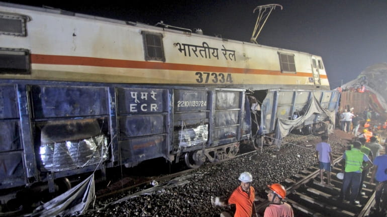 Rescuers work at the site of passenger trains accident, in...