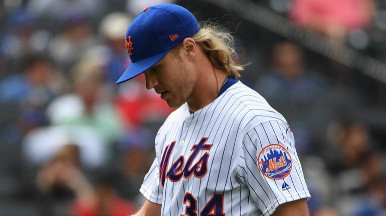 Mets starting pitcher Noah Syndergaard walks to the dugout after...