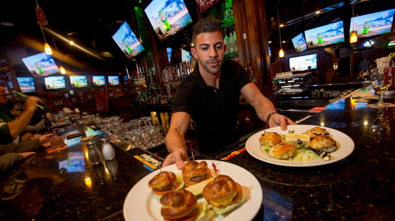 Server and bartender Anthony Bellacosa with a platter of pretzel...