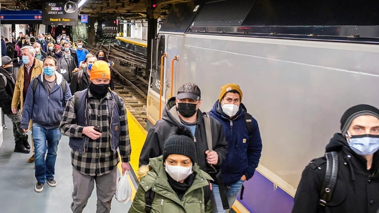 LIRR riders board a train at Penn Station in 2021. Research on masks...