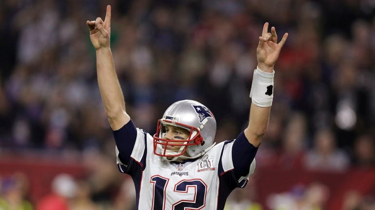 New England Patriots' Tom Brady raises his arms after scoring...