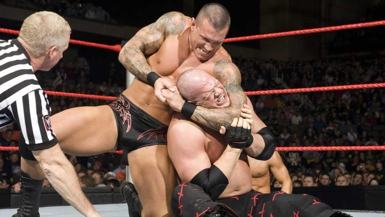 Professional wrestler Randy Orton gives his opponent, Kane, a reverse...