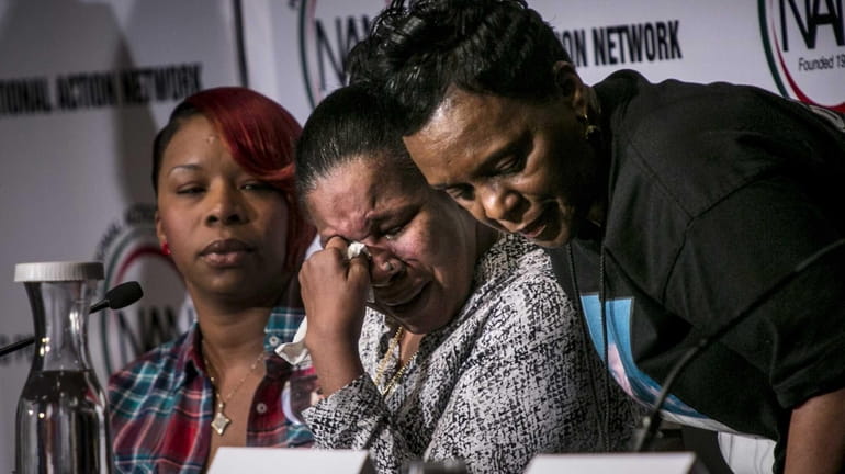 Esaw Garner, center, the widow of Eric Garner, is comforted...