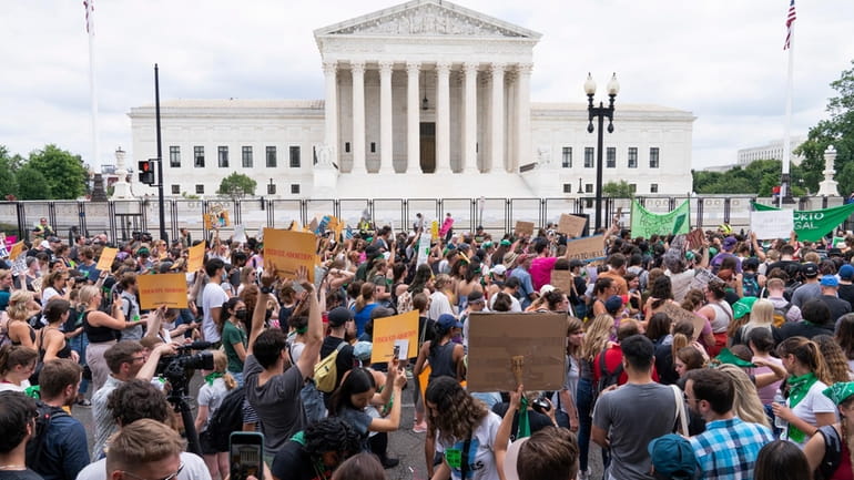 Protesters gather outside the Supreme Court in Washington, Friday, June...