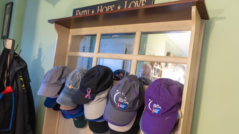 Hats from different cancer events they have attended hang near...