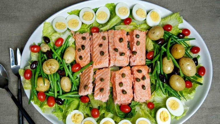 Salmon nicoise salad, prepared with blanched green beans, potatoes, tomatoes,...