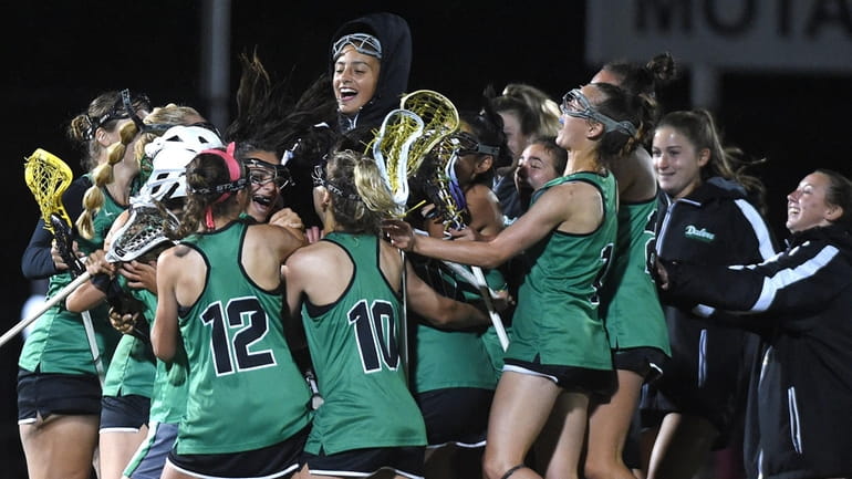Farmingdale girls lacrosse teammates celebrate after their win over Syosset in...
