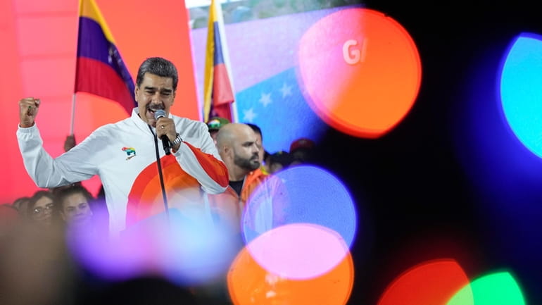 President Nicolas Maduro speaks to pro-government supporters after a referendum...
