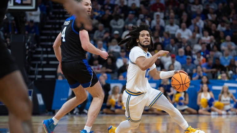 UCLA guard Tyger Campbell (10) dribbles past UNC Asheville forward...