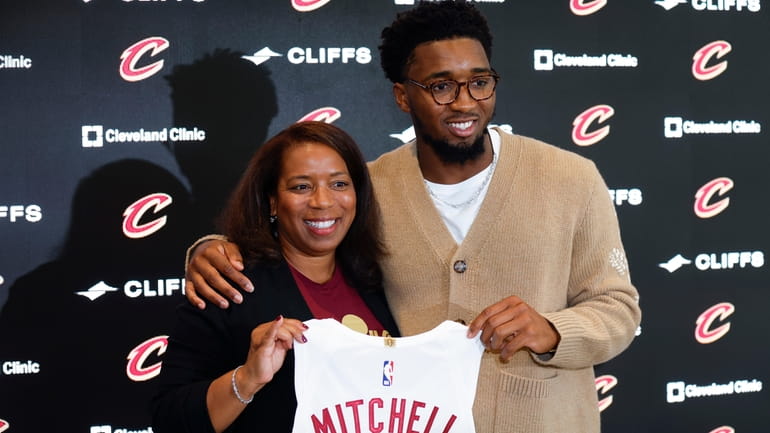 Cavaliers guard Donovan Mitchell and Nicole Mitchell, his mother, hold...