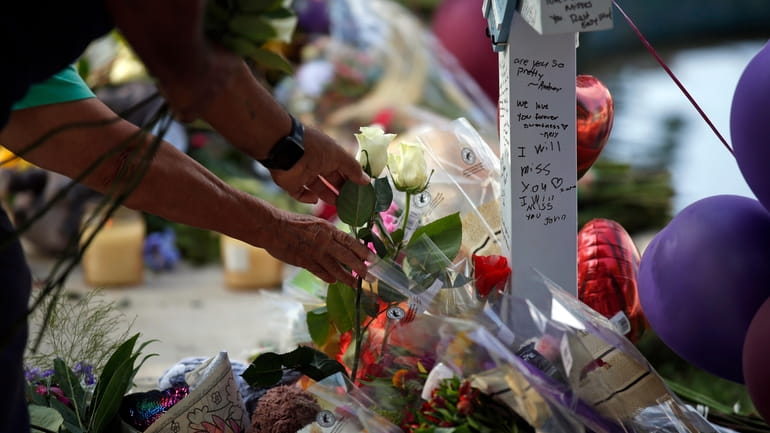 People place flowers at a memorial site for the victims...