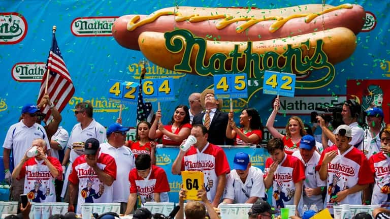 Joey Chestnut (C) competes in the annual Nathan's Hot Dog...