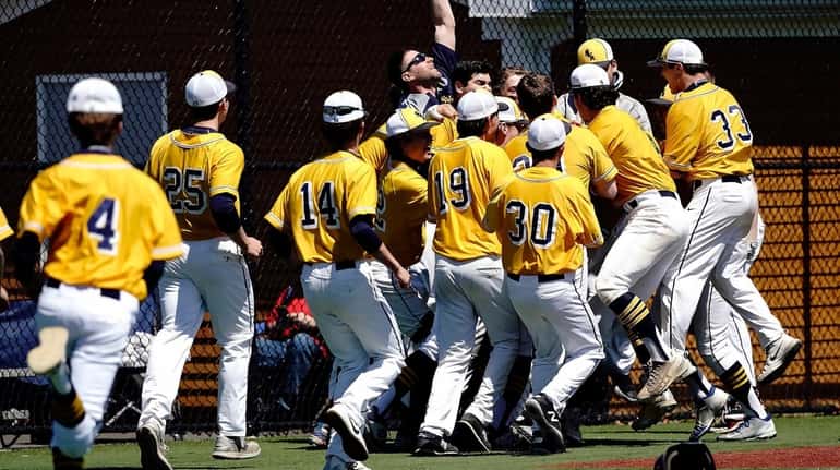 Shoreham-Wading River players surround Mike Smith after he connected for...