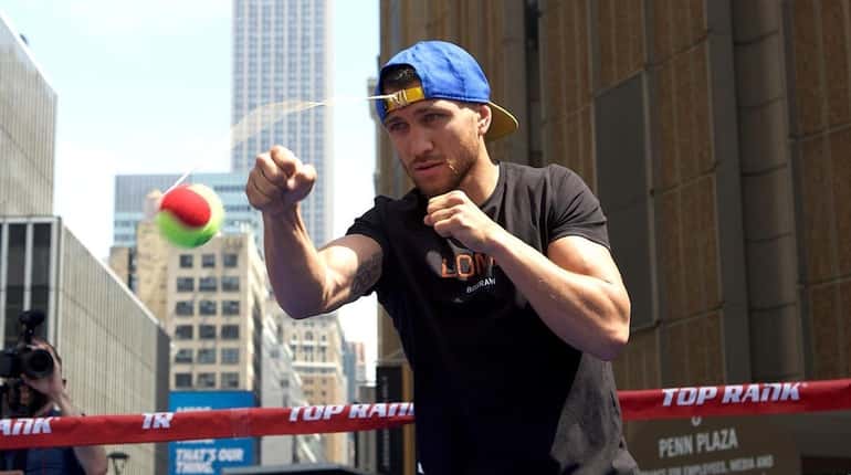 Vasil Lomachenko punches a tennis ball tethered to his baseball...