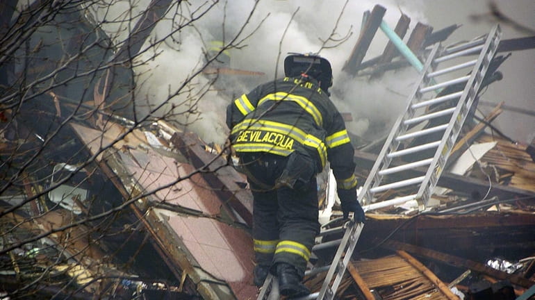 An FDNY firefighter searches for survivors at the scene of...