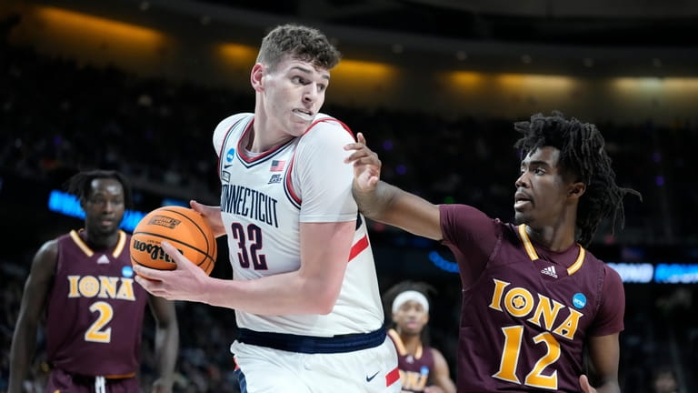 Connecticut's center Donovan Clingan (32) looks to pass against Iona's...