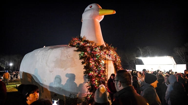People gather around the Big Duck in Flanders for the...