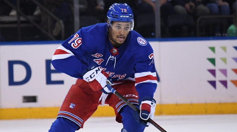 Rangers defenseman K'Andre Miller skates with the puck against the...