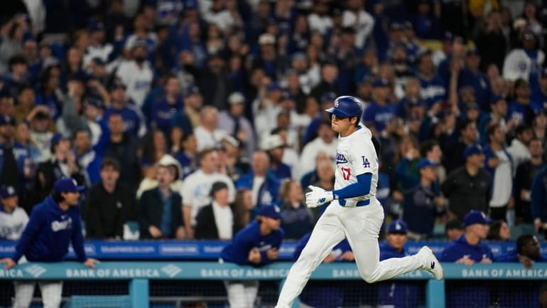 Los Angeles Dodgers designated hitter Shohei Ohtani scores off of...