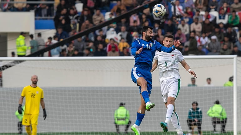 Kuwait's Ali Khalaf, left, vies for the ball with Iraq's...