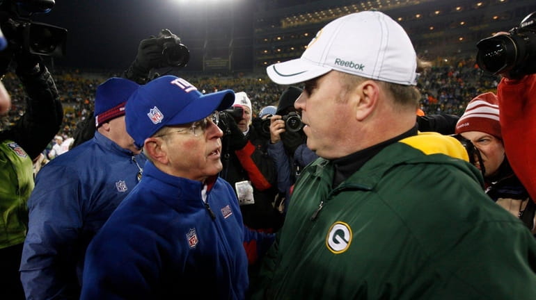 New York Giants coach Tom Coughlin, left, is congratulated by...
