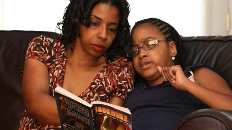 Yvette Tibbs reads to her daughter Tyler, 13. Tyler has...
