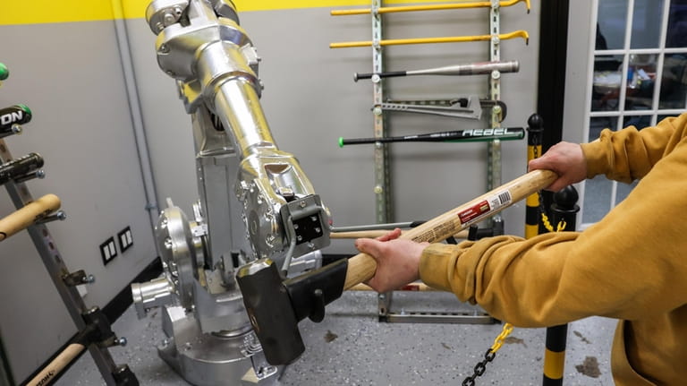 A robot arm hands over a sledgehammer to be used...