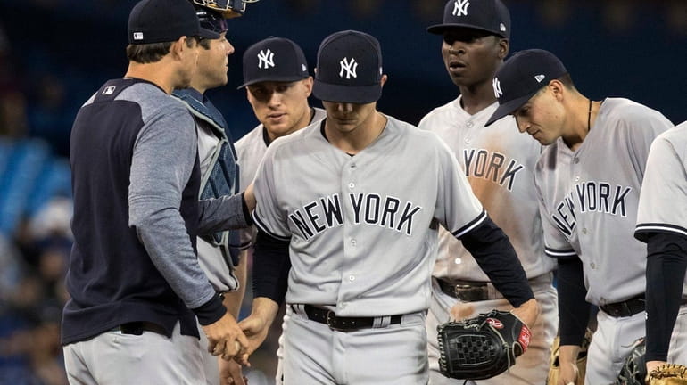Yankees starting pitcher Sonny Gray, center, is taken out of...