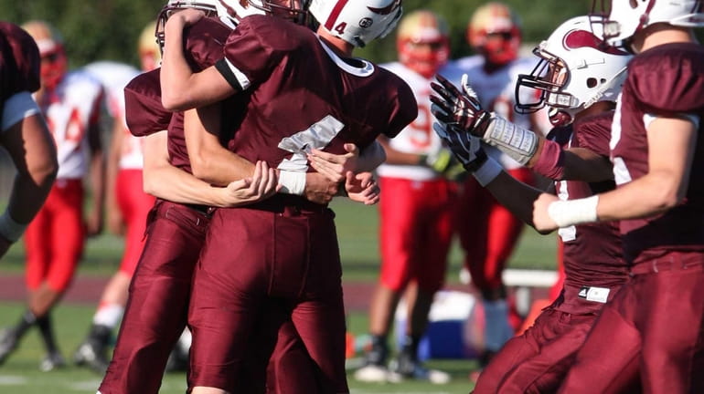 Bay Shore's Matt Smith gets surrounded by teammates after kicking...