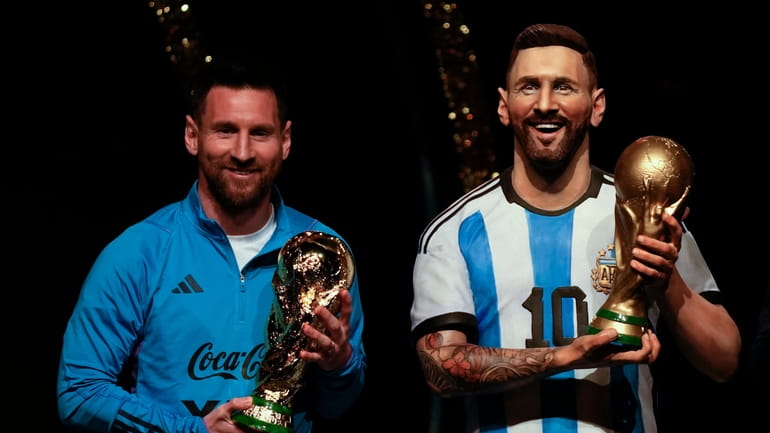 Argentina soccer star Lionel Messi holds a replica of the...