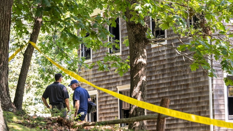Investigators at the scene of an early-morning fire in Noyack...