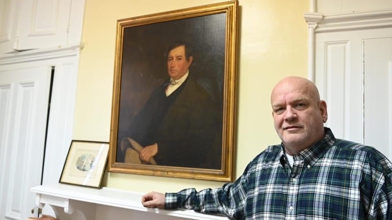Keith Snedecor beside a portrait of his ancestor Eliphalet Snedecor.