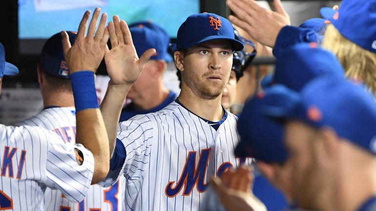 The Mets' Jacob deGrom is greeted in the dugout after...