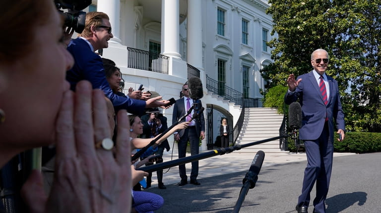 President Joe Biden walks to Marine One after talking with...